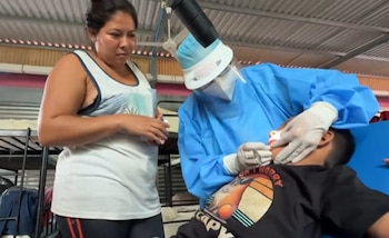 Personal médico realiza una revisión a un menor en un albergue temporal, durante la atención brindada por las lluvias en El Salvador (Cortesía Noticiero El Salvador).
