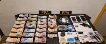 Una mesa negra exhibe fajos de billetes, bolsas con sustancias, una pistola, balas, tres celulares, dos letreros FPA y utensilios metálicos