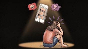 Una mujer sentada en el suelo junto a un teléfono celular con una imagen censurada y dos globos de diálogo con emoticonos.
