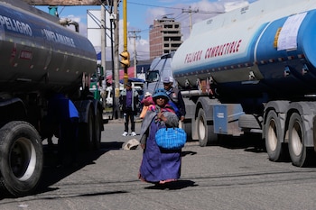 Imagen referencial de archivo. Una mujer pasa junto a camiones cisterna que bloquean una carretera durante una huelga por escasez de diésel en El Alto, Bolivia, el lunes 27 de abril de 2026. (AP Foto/Juan Karita)