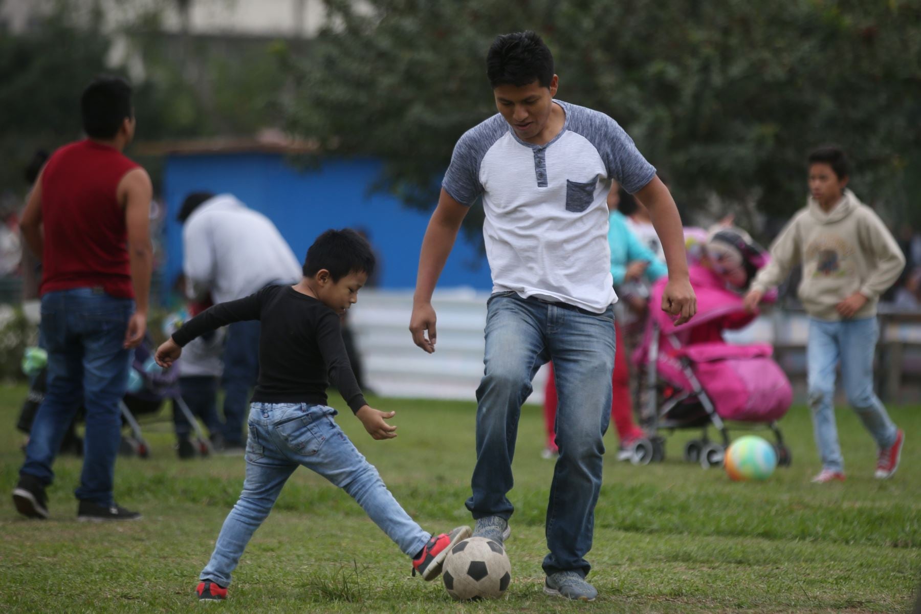 Un padre de familia juega a la pelota en un club metropolitano de Lima un día domingo del año 2024. (Andina)