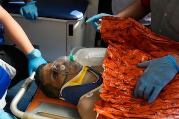 Los equipos de rescate atienden a Hernán Gil Flores tras ser sacado de entre los escombros ocho días después de quedar atrapado por los dos terremotos que azotaron Catia La Mar, Venezuela, el jueves 2 de julio de 2026. (AP Foto/Fernando Vergara)