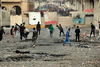 Manifestantes antigubernamentales lanzan piedras mientras