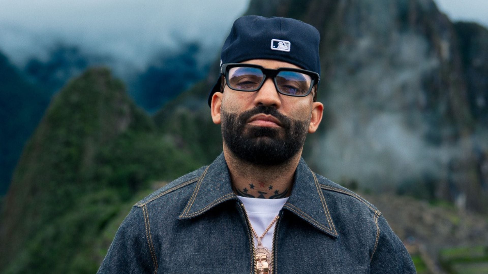 El artista urbano Arcángel posa en un entorno montañoso, previo a su esperado concierto en Lima como parte de su ‘La 8va Maravilla World Tour’.