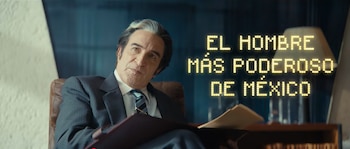 Un hombre canoso de mediana edad con traje y corbata está sentado en un sillón, sosteniendo un folder. Detrás, un cartel luminoso dice "EL HOMBRE MÁS PODEROSO DE MÉXICO"