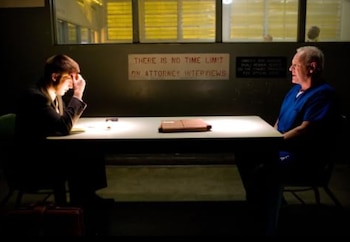 Anthony Hopkins en uniforme azul y un hombre de traje con la cabeza en las manos, sentados en una mesa oscura. Un cartel dice 'THERE IS NO TIME LIMIT ON ATTORNEY INTERVIEWS'