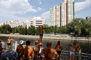 Un hombre se prepara para zambullirse en el río, en medio de una alerta roja por ola de calor en Beijing, China, el 6 de julio de 2023. REUTERS/Tingshu Wang/Archivo