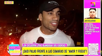 Un hombre con gorra negra y camiseta blanca habla frente a un micrófono en una toma nocturna para televisión