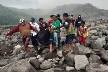 Rescatistas y aldeanos cargan el