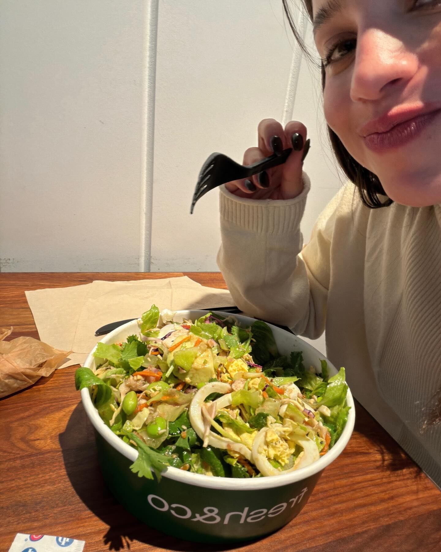 Mernes, de buen humor, posó con un tenedor ante una ensaladera verde en una pausa gastronómica durante el viaje