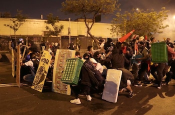 Manifestantes intentan protegerse de los