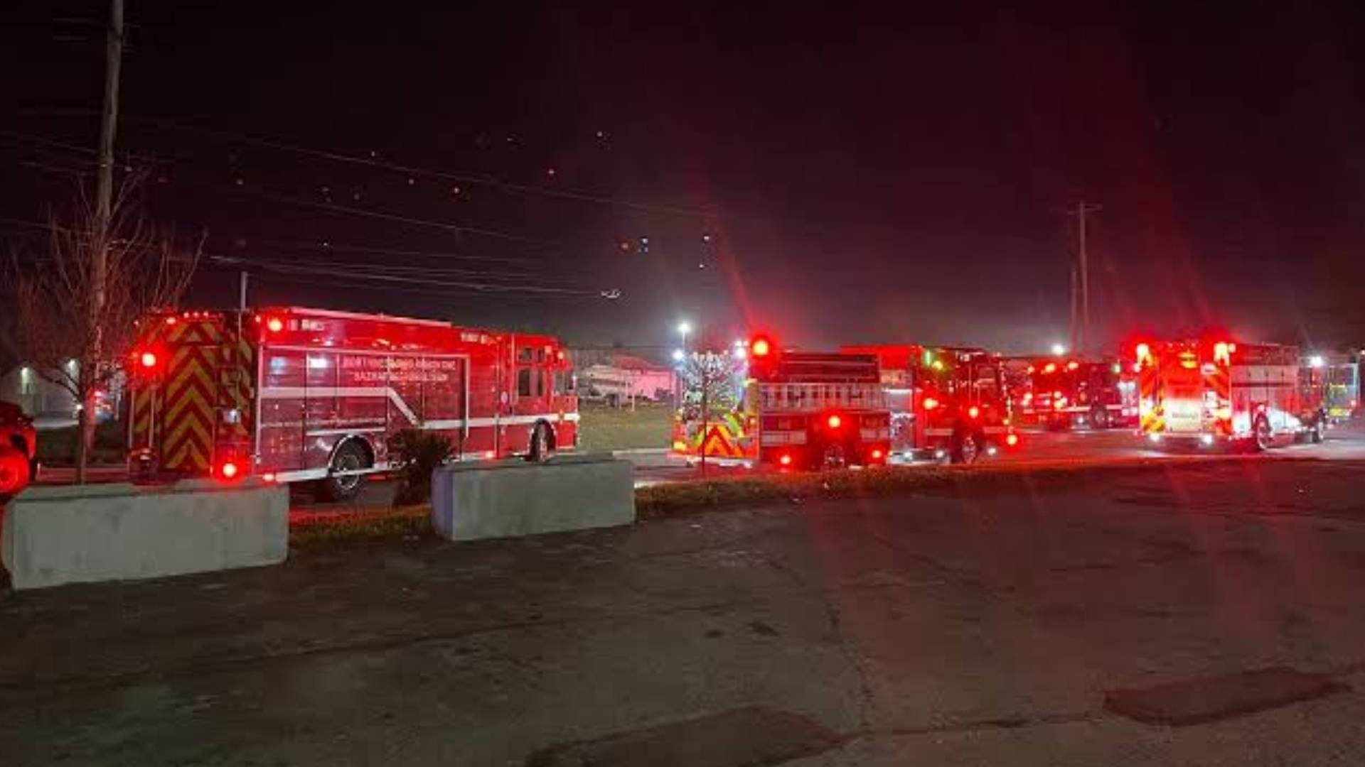 Varios vehículos del cuerpo de bomberos permanecen estacionados con las luces encendidas durante un operativo nocturno en un área urbana. (13abc )