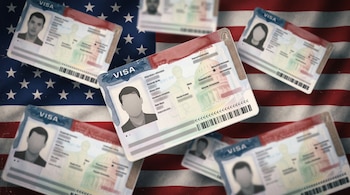 Varias tarjetas de visado de Estados Unidos con fotografías de perfil sobre la bandera estadounidense de barras y estrellas.