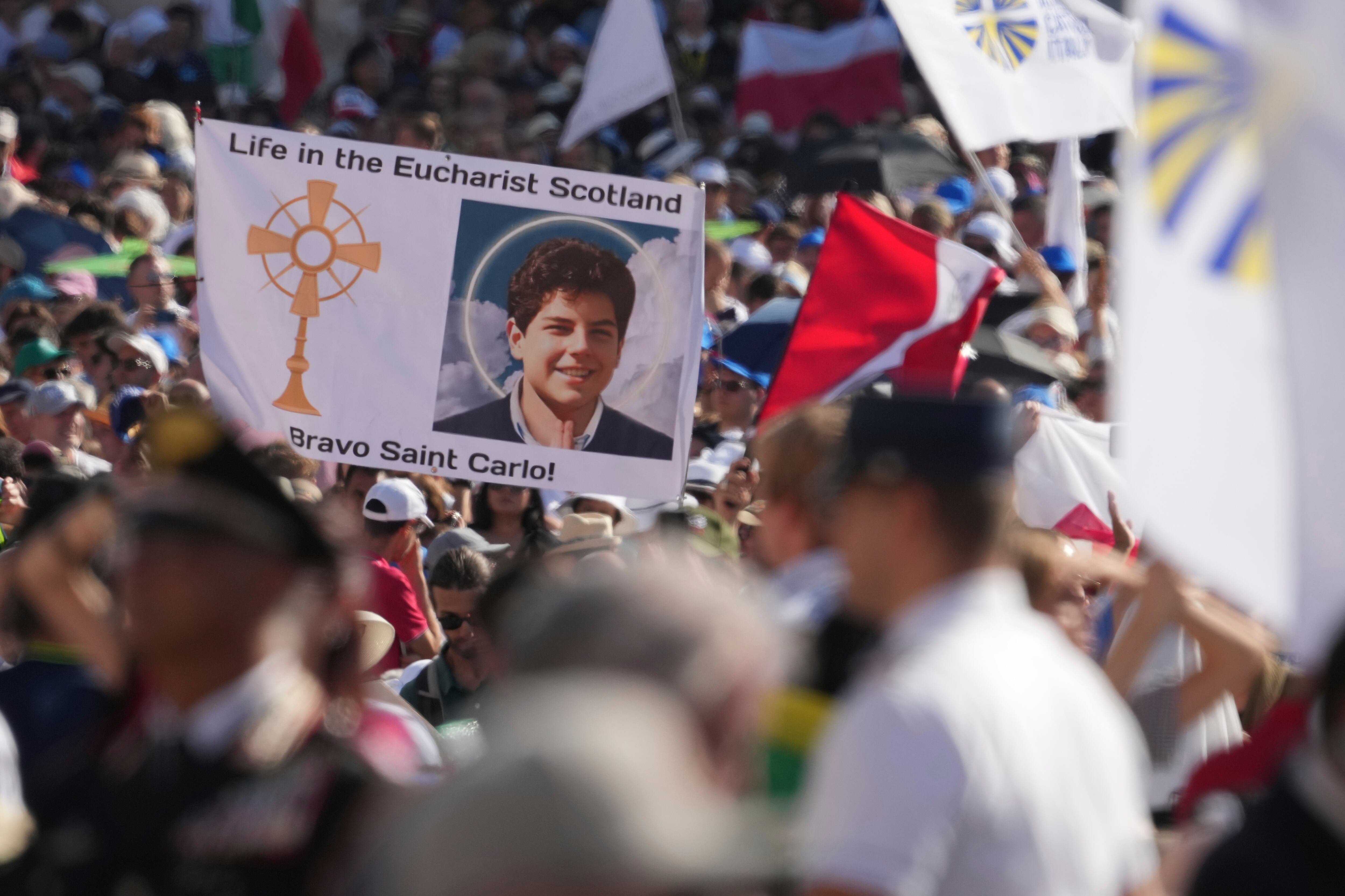 Peregrinos llegan a la misa de canonización de Carlo Acutis y Pier Giorgio Frassati en la Plaza de San Pedro (AP Foto/Andrew Medichini)