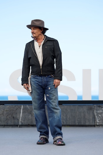 En el San Sebastian Film Festival apareció con sombrero gris, campera negra a rayas finas y jeans anchos, y agregó un pañuelo en el bolsillo y zapatos con salpicaduras de pintura (REUTERS/Vincent West)