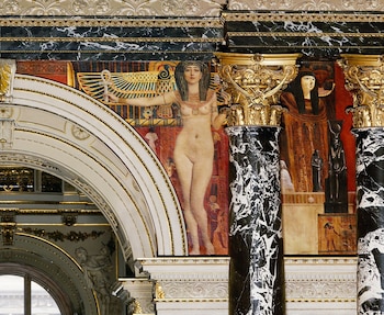 Mural egipcio con figura femenina desnuda sosteniendo un ankh, flanqueada por figuras y jeroglíficos, en un interior decorado con arcos y columnas de mármol
