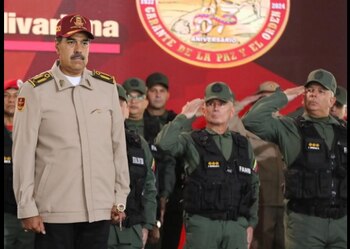 Nicolás Maduro viste chaqueta beige y gorra roja junto a militares con uniforme verde que realizan el saludo militar