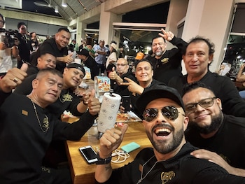 El retorno del reconocido grupo transformó el aeropuerto en un escenario de emotivo júbilo salvadoreño, con multitudes y figuras relevantes del entorno artístico presentes para vivir un momento que marcó historia. Unas alitas de pollo en compañía de otros artistas fue el banquete de cierre tras esta experiencia que llenó de orgullo a El Salvador. (Foto cortesía César Cortez).