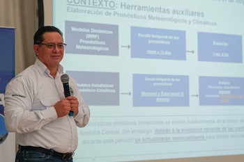 Seis personas con camisetas blancas están sobre un escenario junto a dos carteles azules con el texto Clínicas del Clima