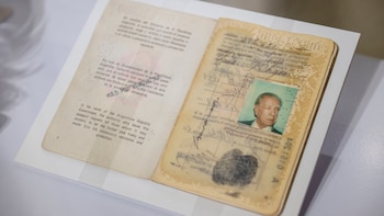 Vista de un pasaporte antiguo abierto, mostrando la página derecha con una foto de un hombre mayor, la firma de Jorge Luis Borges y una huella dactilar. La página izquierda contiene texto