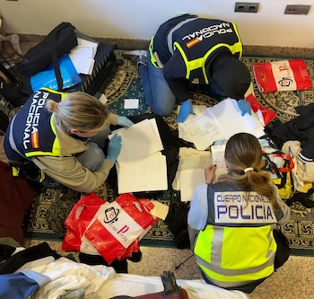 Agentes revisan documentación durante la operación contra la trama de contratos falsos en Roquetas de Mar. (Policía Nacional)