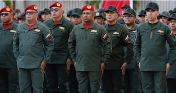 Grupo de hombres con uniformes militares verde oliva, boinas rojas o gorras verdes, parches de la bandera de Venezuela y la sigla FANB