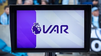 Un monitor negro muestra el logotipo de la Premier League y la sigla VAR en color morado sobre fondo claro.