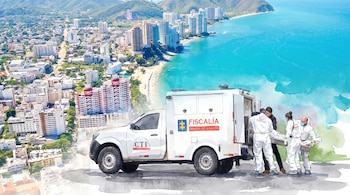 Camioneta de la Fiscalía con logo CTI. Cuatro personas en trajes forenses suben un cuerpo en camilla al vehículo. De fondo, una ciudad costera y montañas.