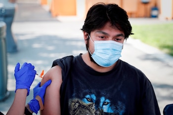 Fotografía de archivo de un joven mientras recibe la segunda dosis de la vacuna Pfizer-BioNTech en Arleta, California (Foto: EFE)