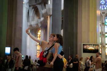 Dos mujeres se hacen un selfie en el interior de la catedral de la Sagrada Familia. (David Zorraquino / Europa Press)