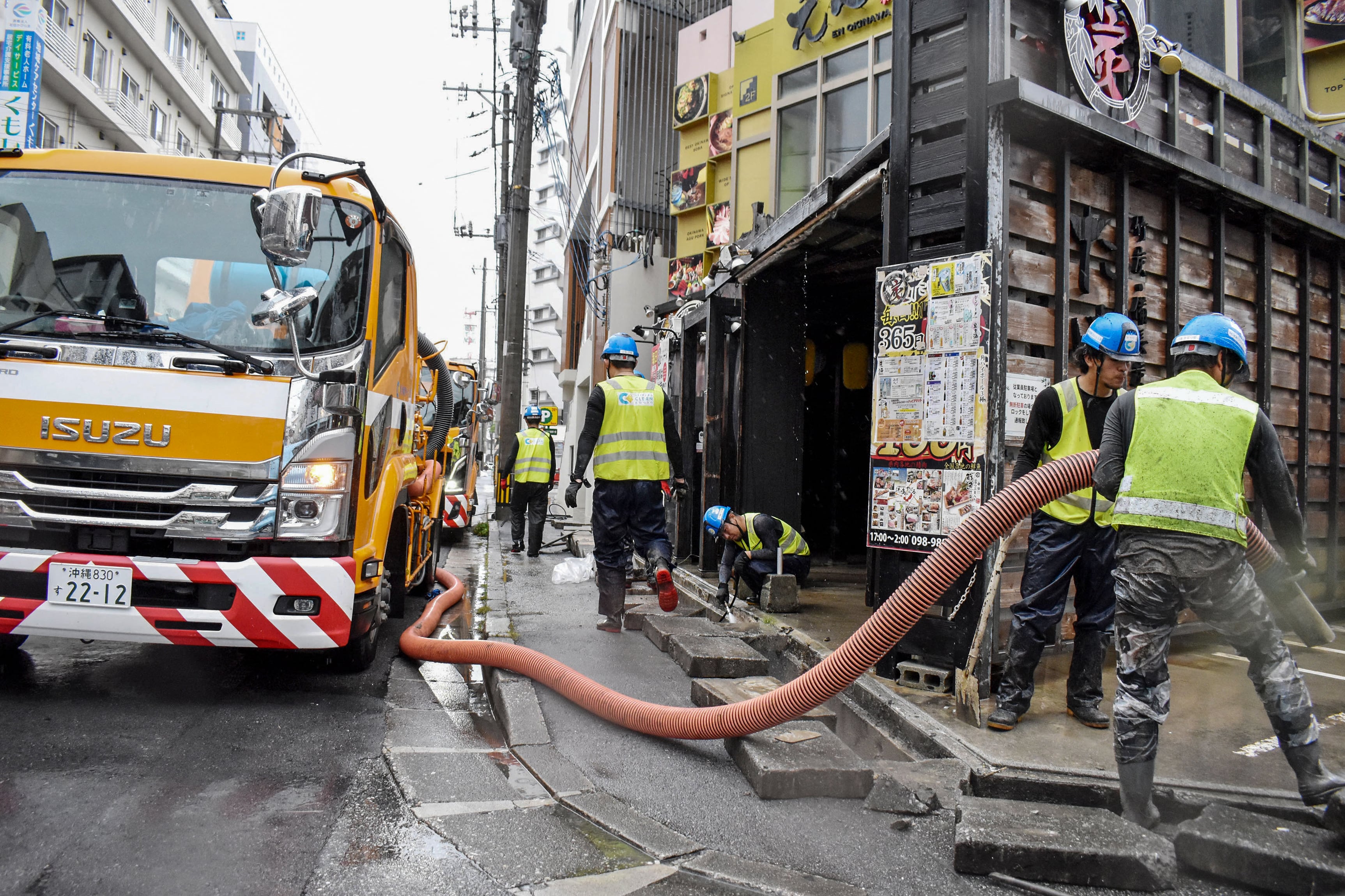 Trabajadores municipales limpian los desagües durante el paso del tifón Saudel en Naha, el 26 de agosto de 2026 (Hiroaki YAMASHIRO/AFP)