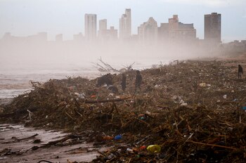 People search for items which they can salvage on the beach after heavy rains caused flooding, in Durban, South Africa, April 12, 2022. REUTERS/Rogan Ward TPX IMAGES OF THE DAY
