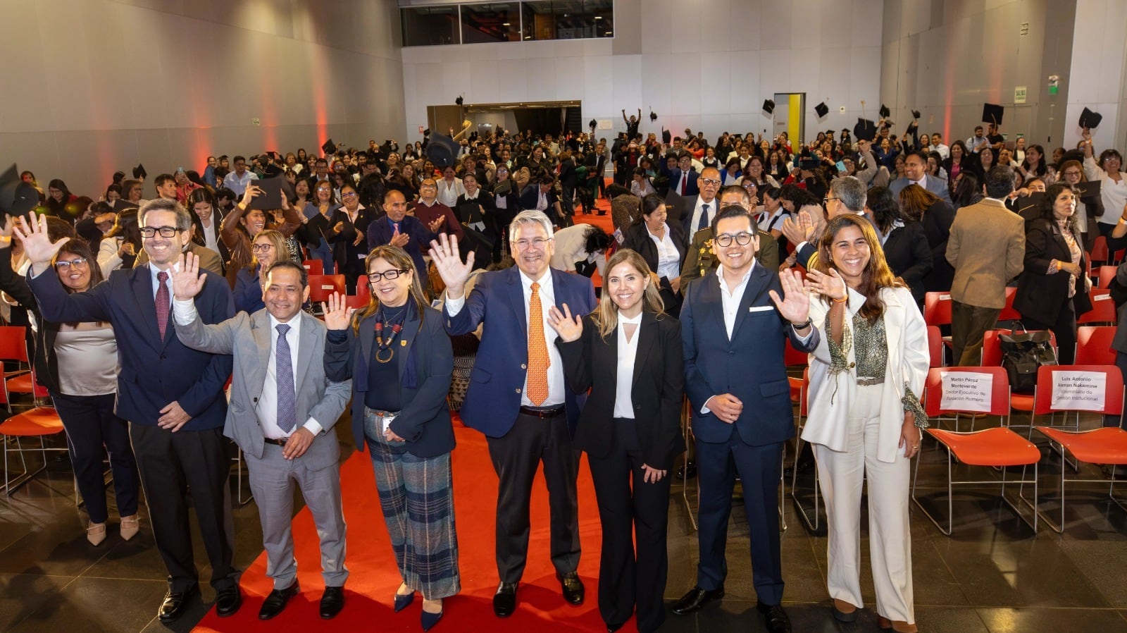Representantes de la Fundación Romero y del Ministerio de Educación saludan junto a profesores en una ceremonia en el Centro de Convenciones de Lima.