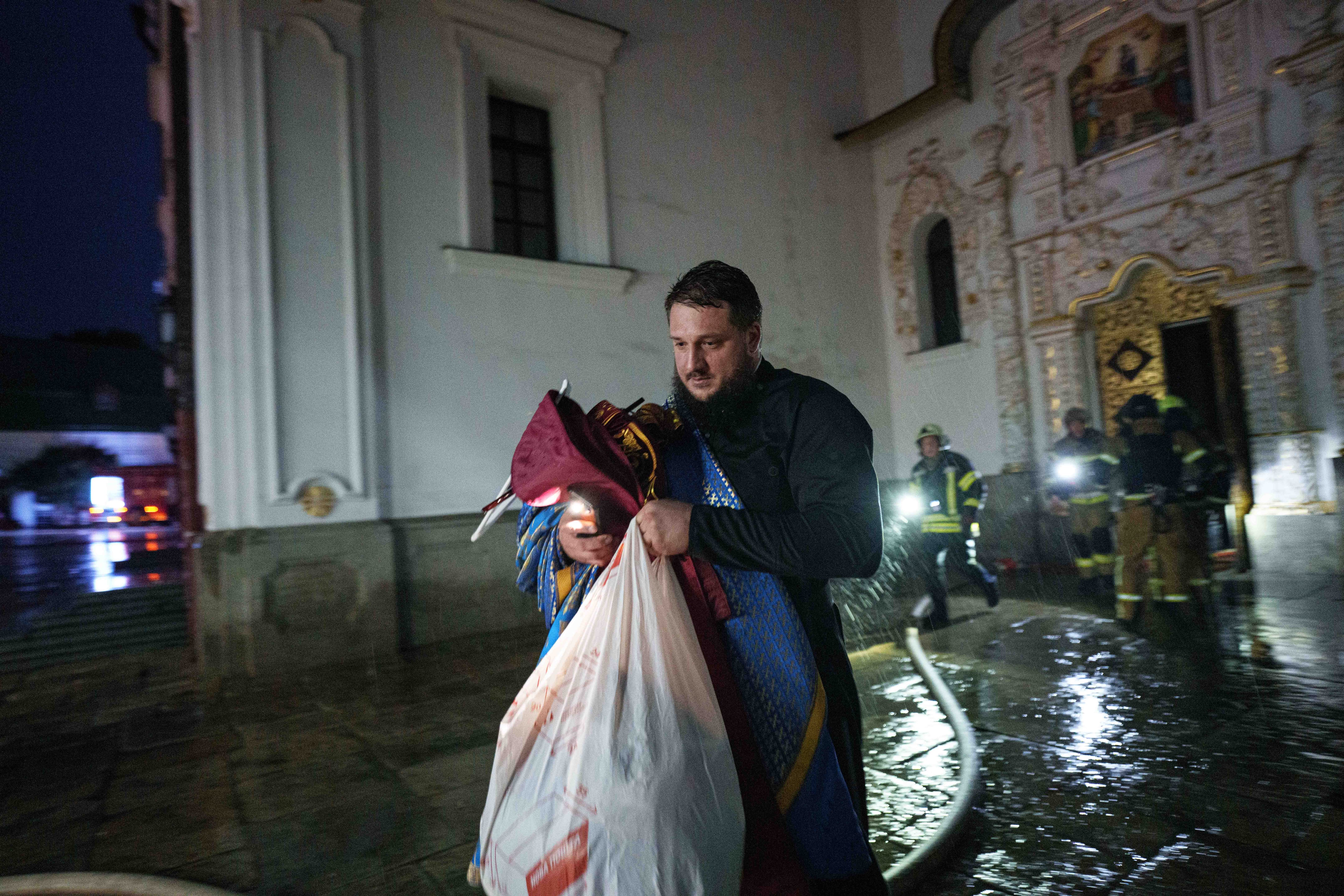 Clérigos intentaron salvar objetos del complejo mientras los bomberos combatían el incendio. El Monasterio de las Cuevas reviste especial significado para los cristianos ortodoxos de Ucrania y Rusia. (AP Photo/Evgeniy Maloletka)