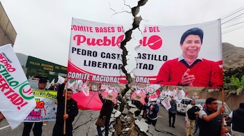 Manifestación política con personas sosteniendo banderas y pancartas con la imagen de Pedro Castillo, atravesada por una grieta visual.