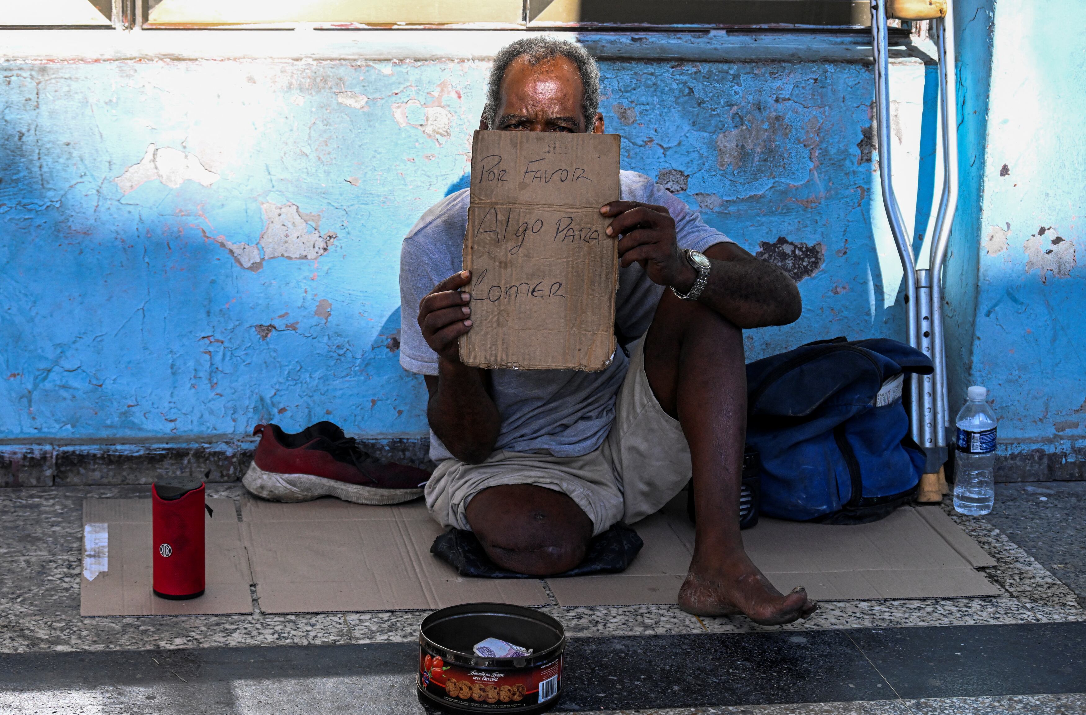 Un adulto mayor pide ayuda en la calle (Yamil LAGE/AFP)