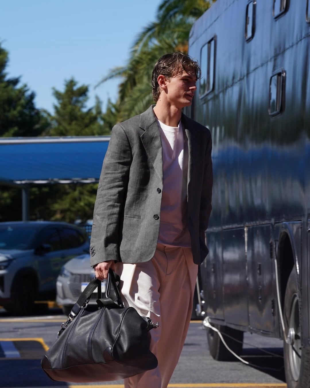 Nico Paz, de saco, arribando a la concentración de Argentina en Ezeiza