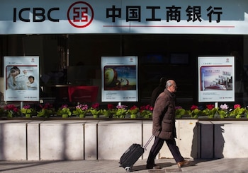 FOTO DE ARCHIVO. Un hombre lleva una maleta mientras pasa frente a una sucursal del Banco Industrial y Comercial de China (ICBC) en el centro de Madrid, España. 24 de enero de 2011. REUTERS/Juan Medina