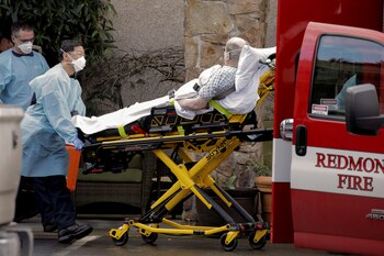 Médicos transportan a un hombre en camilla a una ambulancia en el Life Care Center, un centro de cuidados a largo plazo relacionado con varios casos confirmados de coronavirus, en Kirkland, Washington, EEUU, el 3 de marzo de 2020 (REUTERS/David Ryder)