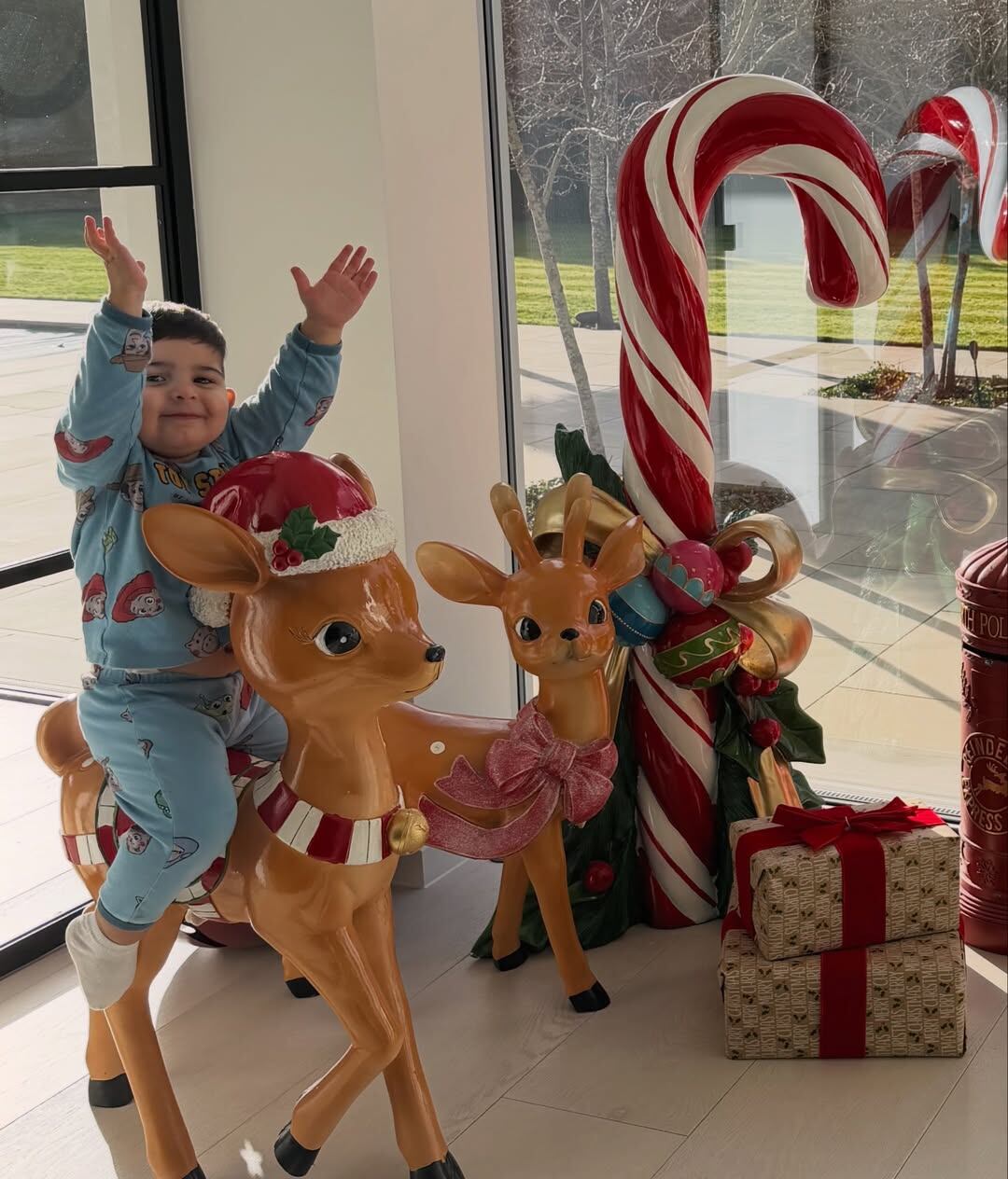 Benjamín, el hijo menor de la pareja, feliz arriba de un reno que es parte de la decoración navideña de su hogar