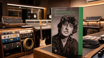 Un libro con el rostro de Charly García en la portada se encuentra frente a consolas y equipos de audio en un estudio de grabación.