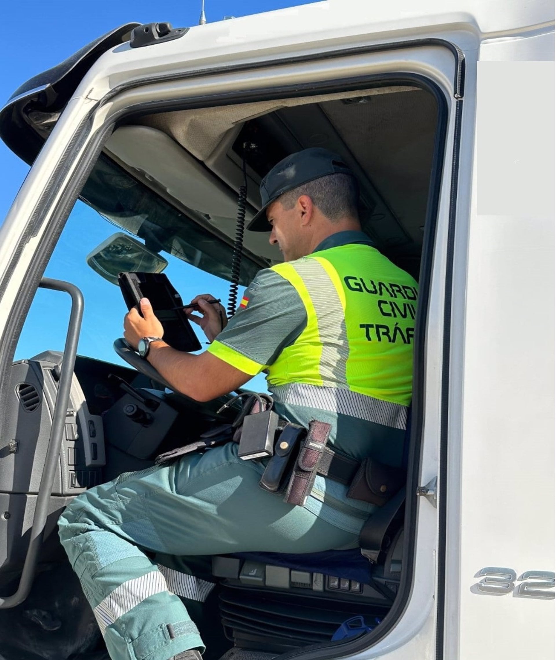 Agente de la Guardia Civil de Tráfico revisa los datos de un vehículo pesado