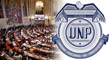 Sala del congreso con asistentes sentados, mural, pantalla, y el logotipo de la Unidad Nacional de Protección (UNP) de Colombia con águila y texto.