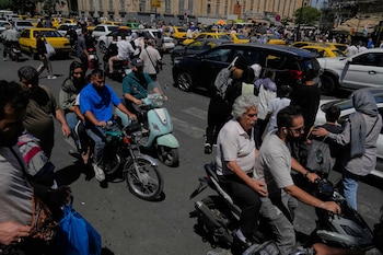 Peatones y vehículos cruzan una intersección en los alrededores del histórico Gran Bazar de Teherán, el lunes 1 de junio de 2026. El presidente iraní, Masoud Pezeshkian, advirtió en mayo: "Definitivamente tendremos precios más altos". (AP Photo/Vahid Salemi)