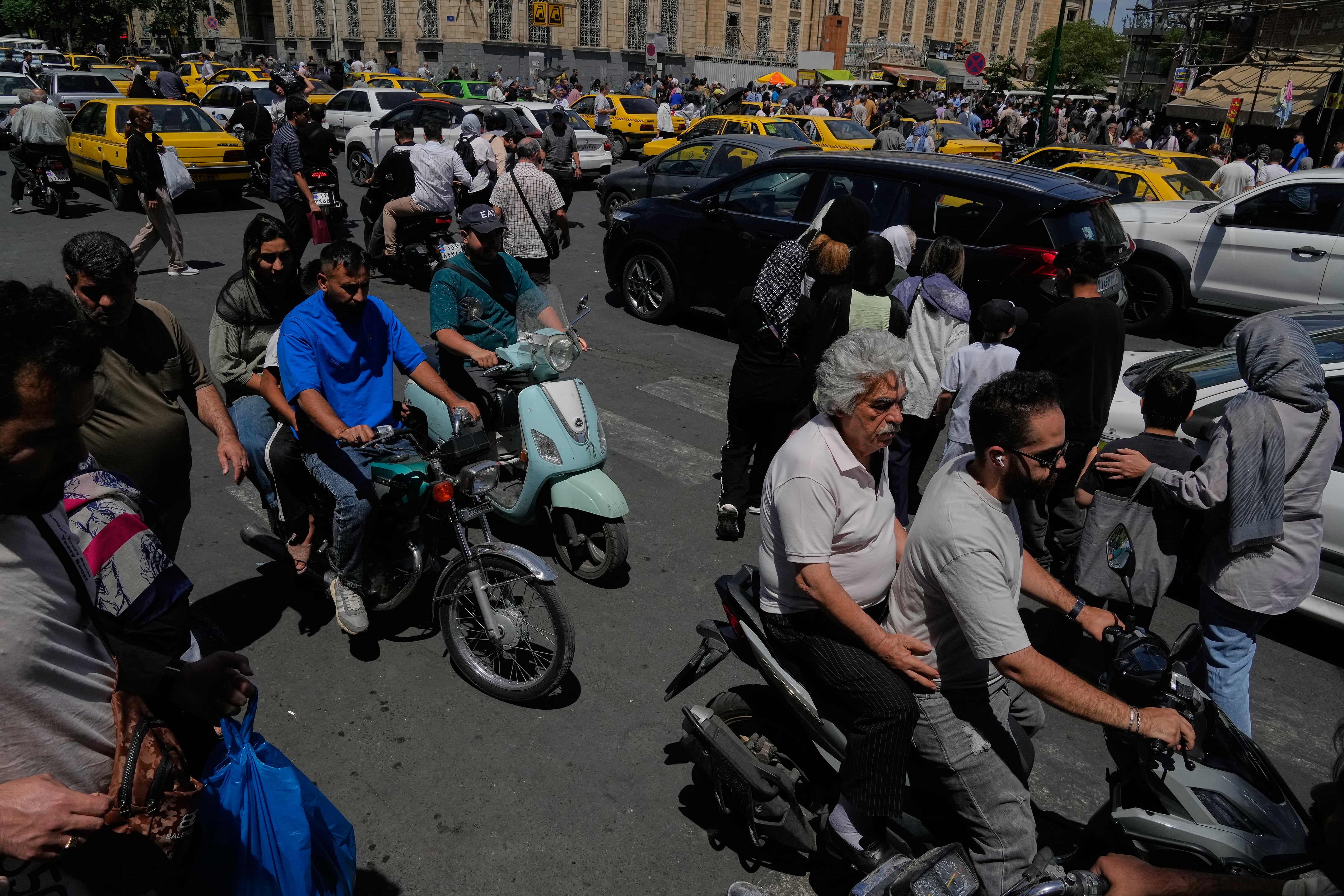 Peatones y vehículos cruzan una intersección en los alrededores del histórico Gran Bazar de Teherán, el lunes 1 de junio de 2026. El presidente iraní, Masoud Pezeshkian, advirtió en mayo: