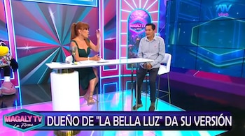 Mujer pelirroja con vestido verde y hombre con camisa a rayas sentados en un estudio de televisión con una mesa entre ellos