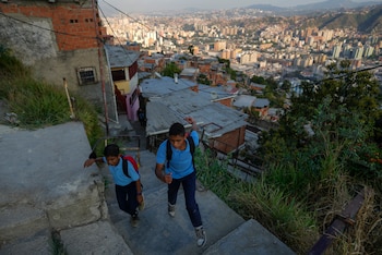 Dos niños ascienden por unas escaleras en el vecindario de Catia, el miércoles 1 de marzo de 2023, en Caracas, Venezuela. (AP Foto/Ariana Cubillos)