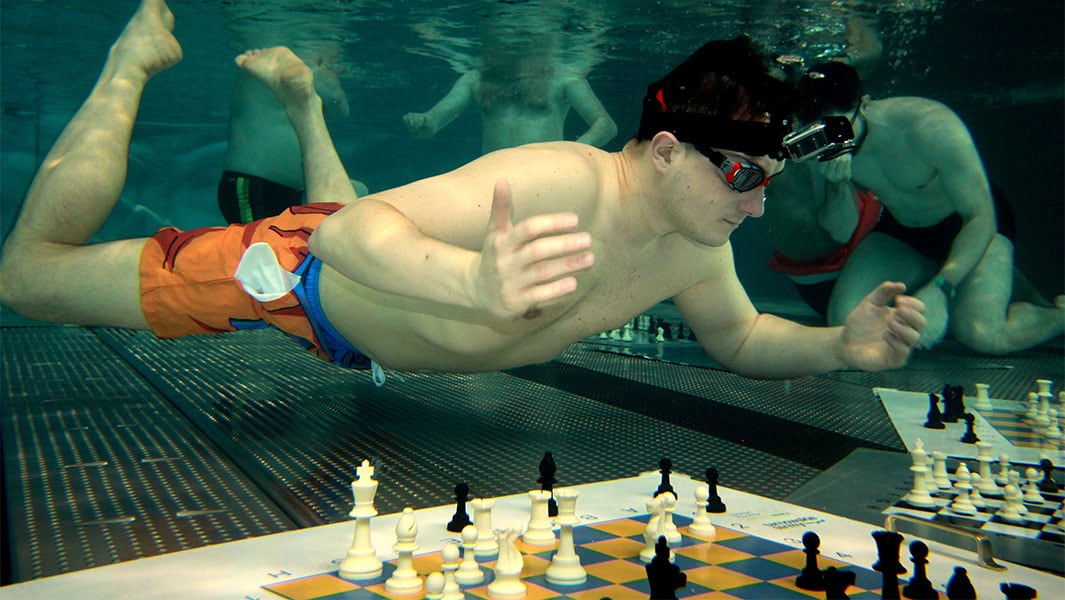 Michał Mazurkiewicz logró en 2024 un Récord Guinness en ajedrez subacuático tras enfrentar en simultáneo a 16 rivales con una sola respiración por jugada (Créditos: Récord Guinness)