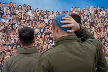 Soldados israelíes miran fotos de personas asesinadas por milicianos de Hamás en un ataque transfronterizo perpetrado el 7 de octubre de 2023 en el festival musical Nova, durante una visita al lugar en Re'im, en el sur de Israel, cerca de la frontera con Gaza, el 28 de enero de 2024. (AP Foto/Oded Balilty, Archivo)