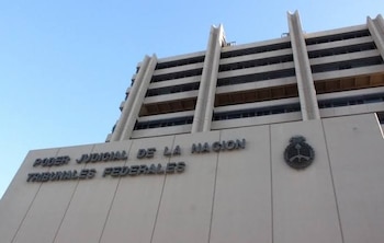 Vista en ángulo contrapicado de un edificio con la inscripción Poder Judicial de la Nación Tribunales Federales y un escudo nacional